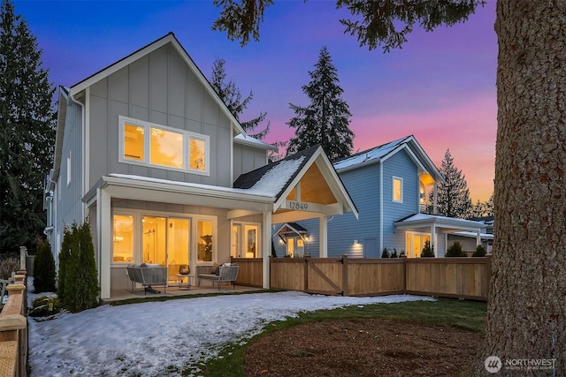 back house at dusk featuring a porch