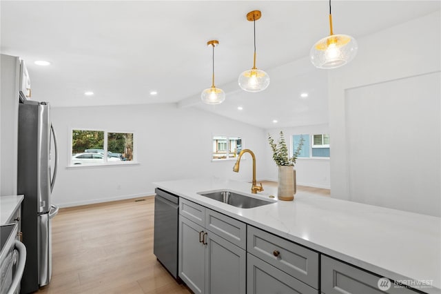 kitchen featuring plenty of natural light, sink, gray cabinets, appliances with stainless steel finishes, and pendant lighting