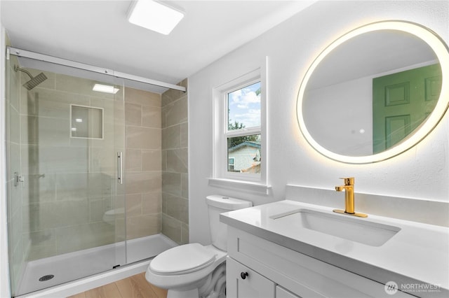 bathroom with toilet, vanity, an enclosed shower, and wood-type flooring