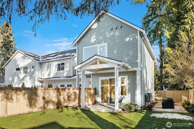 back of house featuring a patio area and a lawn