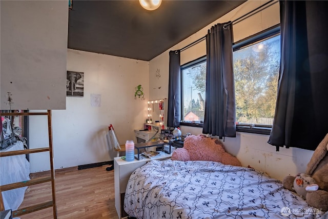 bedroom featuring baseboards and wood finished floors