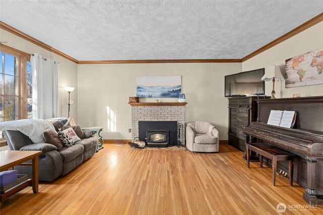 living room with crown molding, light hardwood / wood-style floors, and a textured ceiling