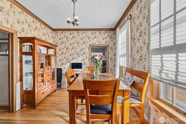 dining room featuring ornamental molding, a chandelier, and light hardwood / wood-style floors