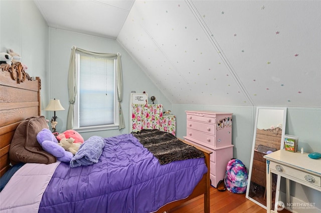 bedroom with vaulted ceiling and hardwood / wood-style floors