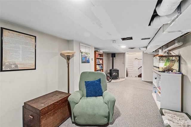 sitting room featuring light carpet and a wood stove