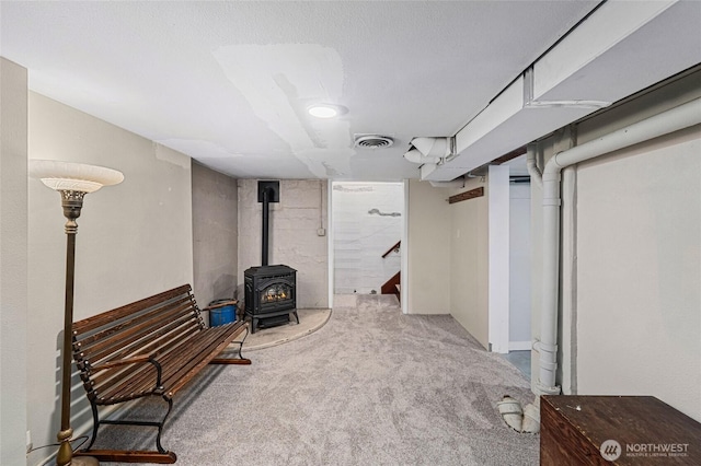 404 N Maple St, Colville, WA 99114 - finished below grade area with carpet flooring, a wood stove, and stairway
