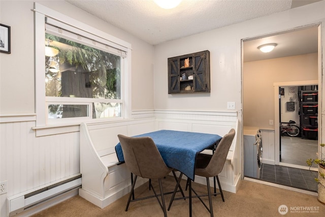 dining space with baseboard heating, light colored carpet, breakfast area, and a textured ceiling