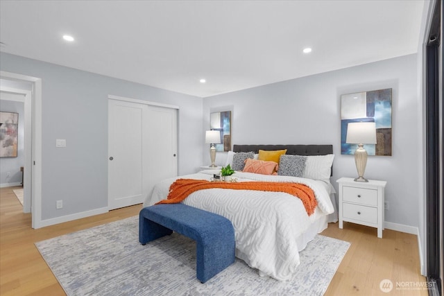 bedroom with light wood-type flooring and a closet