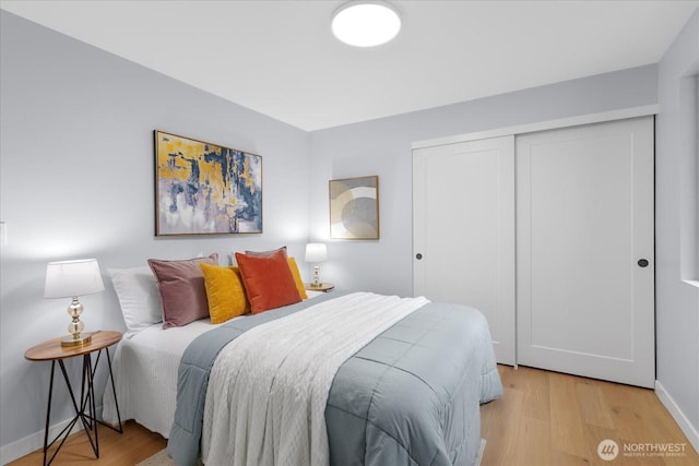 bedroom with light hardwood / wood-style floors and a closet