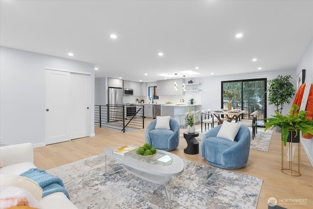 living room with light wood-type flooring and sink