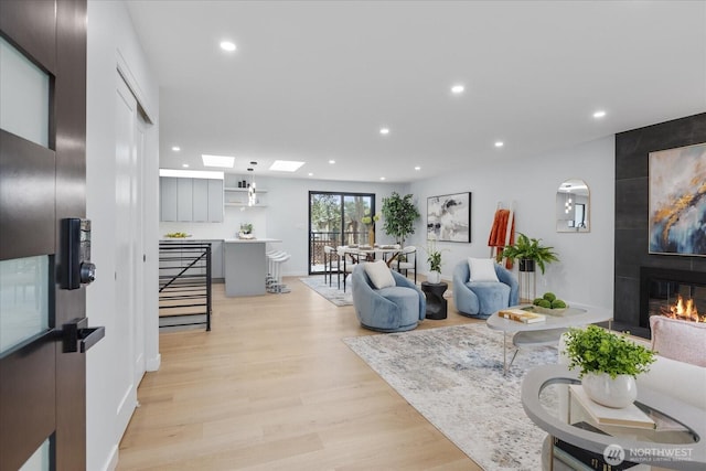 living room featuring a large fireplace and light wood-type flooring