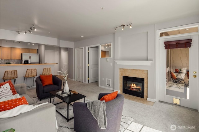 living room with light colored carpet and a tile fireplace