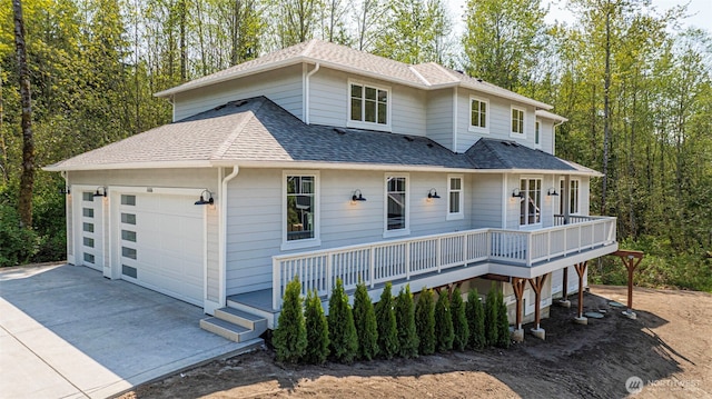 16806 62nd St SE, Snohomish, WA 98290 - view of front facade featuring driveway, a shingled roof, a wooden deck, and a garage