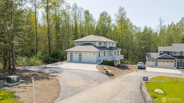 16806 62nd St SE, Snohomish, WA 98290 - traditional home featuring covered porch, a forest view, aphalt driveway, roof with shingles, and an attached garage