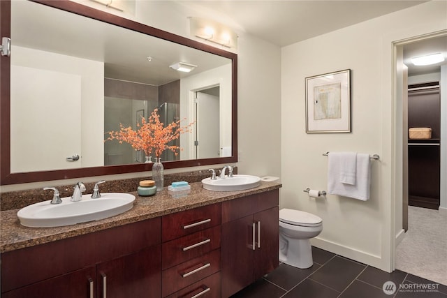 bathroom featuring tile patterned flooring, vanity, toilet, and walk in shower