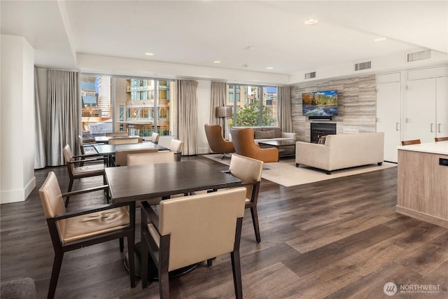 dining space featuring dark wood-type flooring and a fireplace