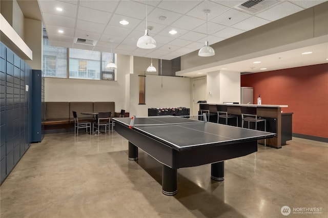 rec room with bar and a paneled ceiling