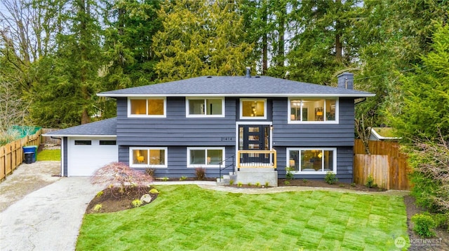 bi-level home with a garage and a front lawn