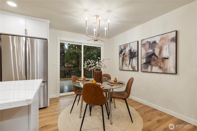 dining space featuring a notable chandelier and light hardwood / wood-style floors