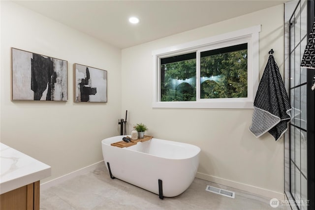 bathroom featuring vanity and a bath