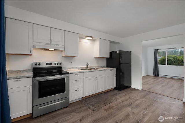 kitchen featuring stainless steel electric range, light countertops, a sink, and freestanding refrigerator