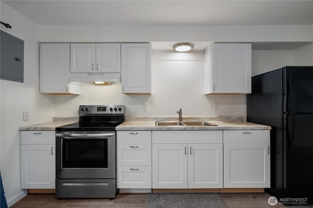 kitchen with under cabinet range hood, a sink, white cabinetry, stainless steel range with electric cooktop, and light countertops