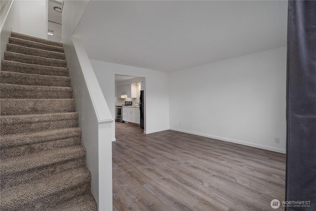 stairway featuring baseboards and wood finished floors