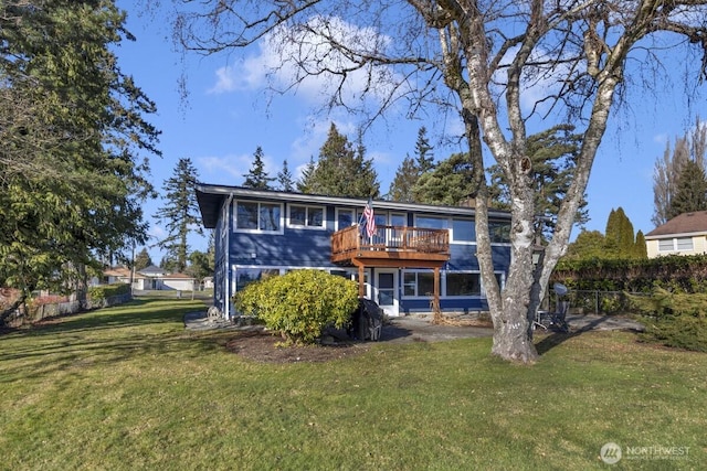 rear view of property with a yard and a wooden deck