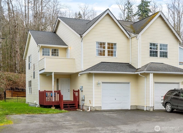 multi unit property featuring driveway, a shingled roof, and an attached garage