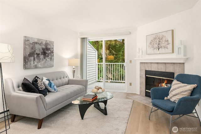 living area with a tiled fireplace and wood finished floors