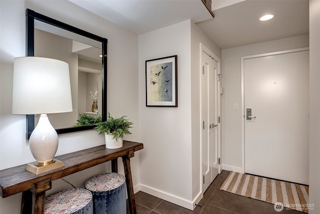 foyer entrance with dark tile patterned flooring, baseboards, and recessed lighting