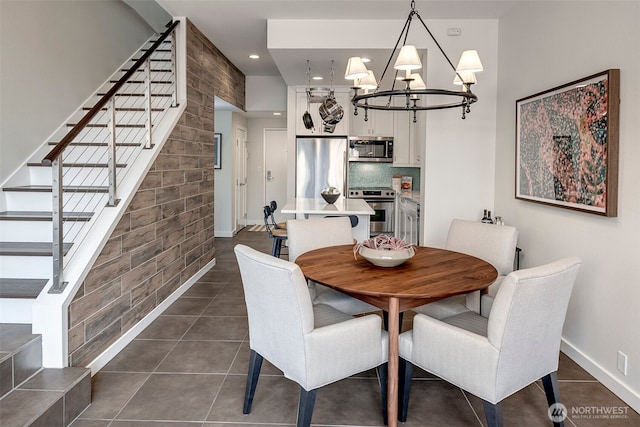 dining space with baseboards, dark tile patterned flooring, stairs, a chandelier, and recessed lighting