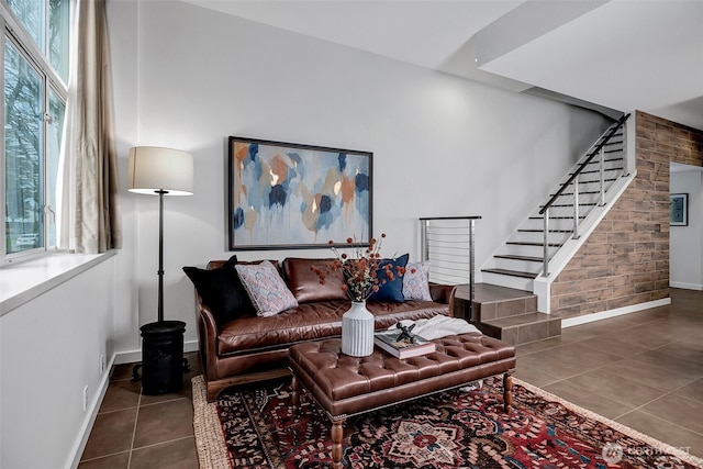 tiled living room featuring stairs and baseboards