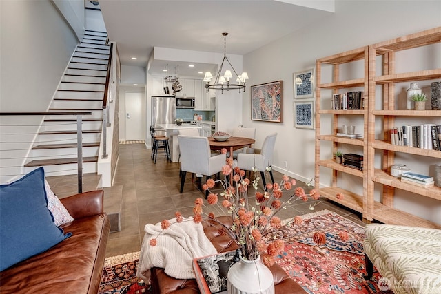 dining room featuring recessed lighting, an inviting chandelier, dark tile patterned flooring, baseboards, and stairs