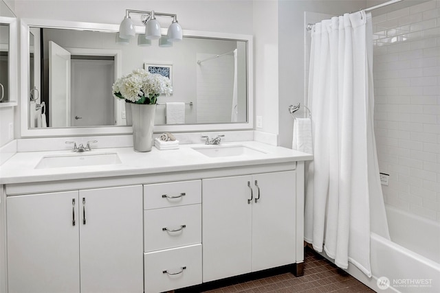 bathroom with double vanity, shower / bath combo, and a sink