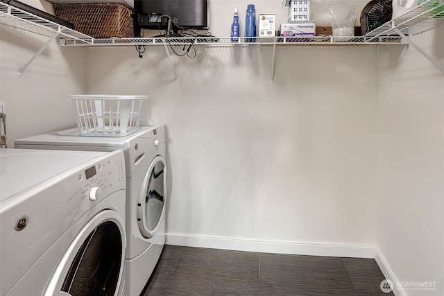 clothes washing area with laundry area, washing machine and clothes dryer, and baseboards