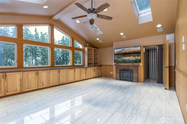 unfurnished living room featuring visible vents, a ceiling fan, lofted ceiling with skylight, a fireplace, and recessed lighting