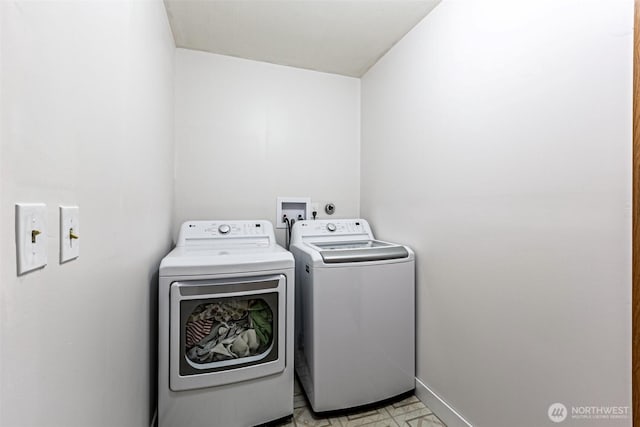 laundry area with laundry area, separate washer and dryer, and baseboards