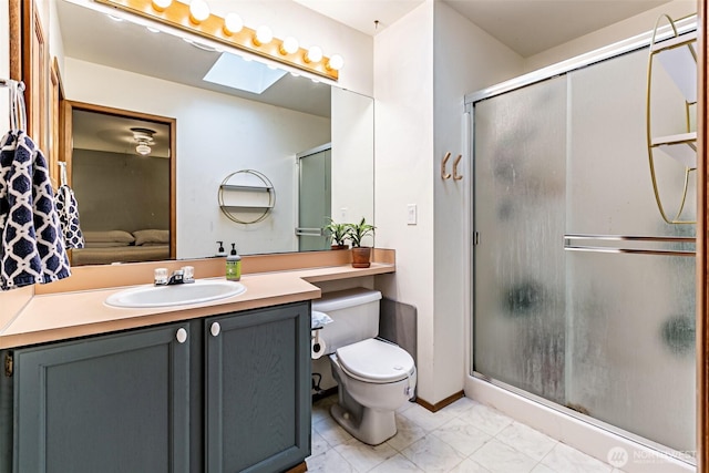 ensuite bathroom featuring a stall shower, a skylight, toilet, ensuite bathroom, and vanity