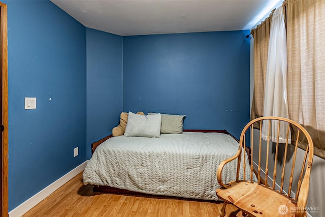 bedroom with baseboards and wood finished floors