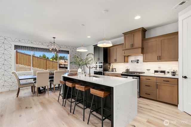 kitchen featuring a breakfast bar area, stainless steel appliances, light countertops, light wood-style floors, and recessed lighting