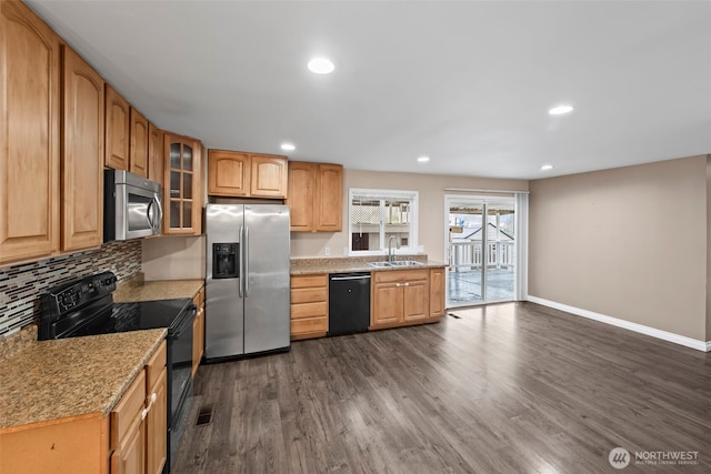 kitchen featuring sink, dark hardwood / wood-style flooring, light stone countertops, decorative backsplash, and black appliances