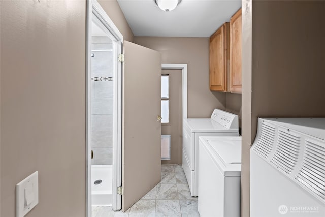 washroom with cabinets and washing machine and dryer