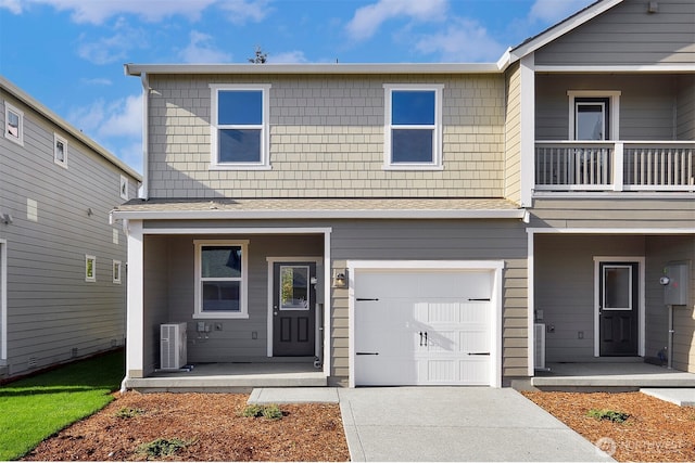 view of property featuring a garage and central AC