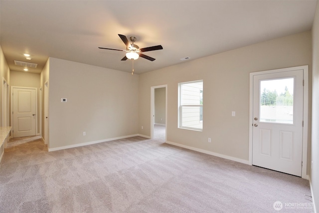 carpeted spare room featuring a wealth of natural light and ceiling fan