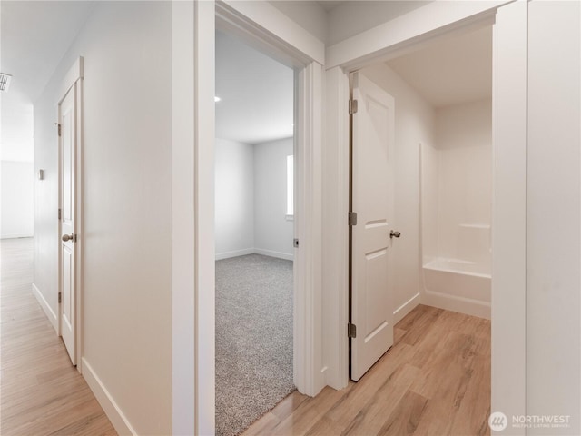 corridor with light hardwood / wood-style flooring