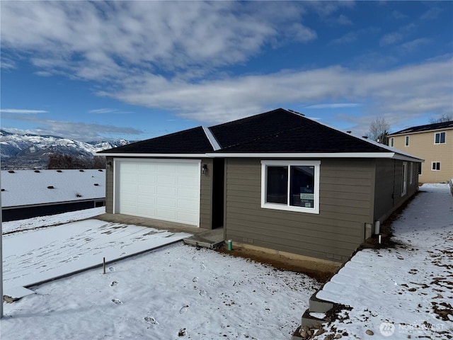 exterior space with a garage and a mountain view