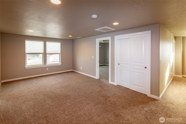 unfurnished bedroom with a closet, a textured ceiling, and carpet