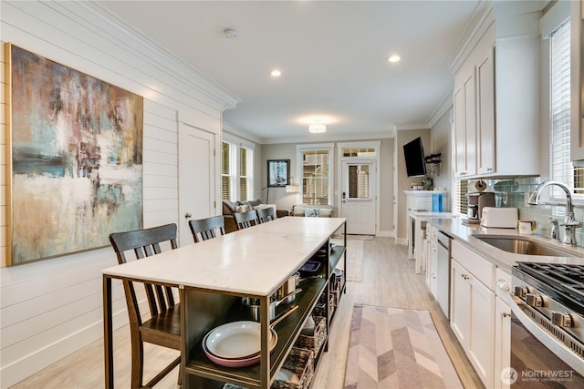 kitchen featuring white cabinetry, sink, a kitchen island, and a kitchen breakfast bar