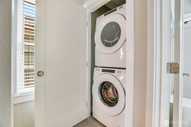 washroom featuring stacked washer / drying machine